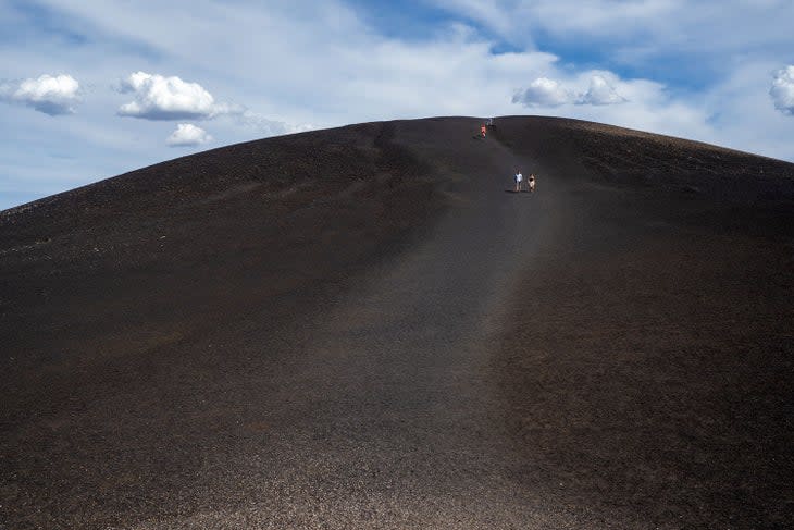 Hikers walking down Inferno Cone in Craters of the Moon National Monument