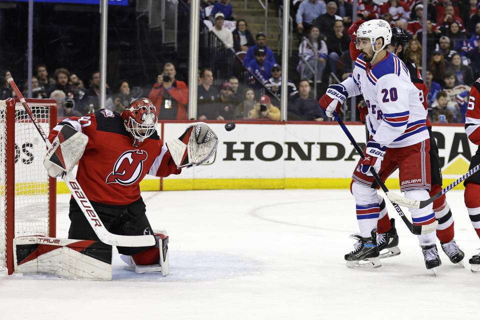 New Jersey Devils goaltender Akira Schmid makes a save in front of New York Rangers left wing Chris Kreider (20) during the first period of Game 7 of an NHL hockey Stanley Cup first-round playoff series Monday, May 1, 2023, in Newark, N.J. (AP Photo/Adam Hunger)