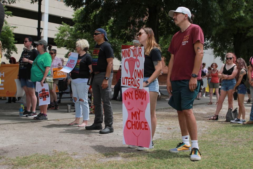 Amy Crawford holds signs during the Reproductive Rights Protesting, Augusta rally at the Augusta Common on Saturday, May 21, 2022.