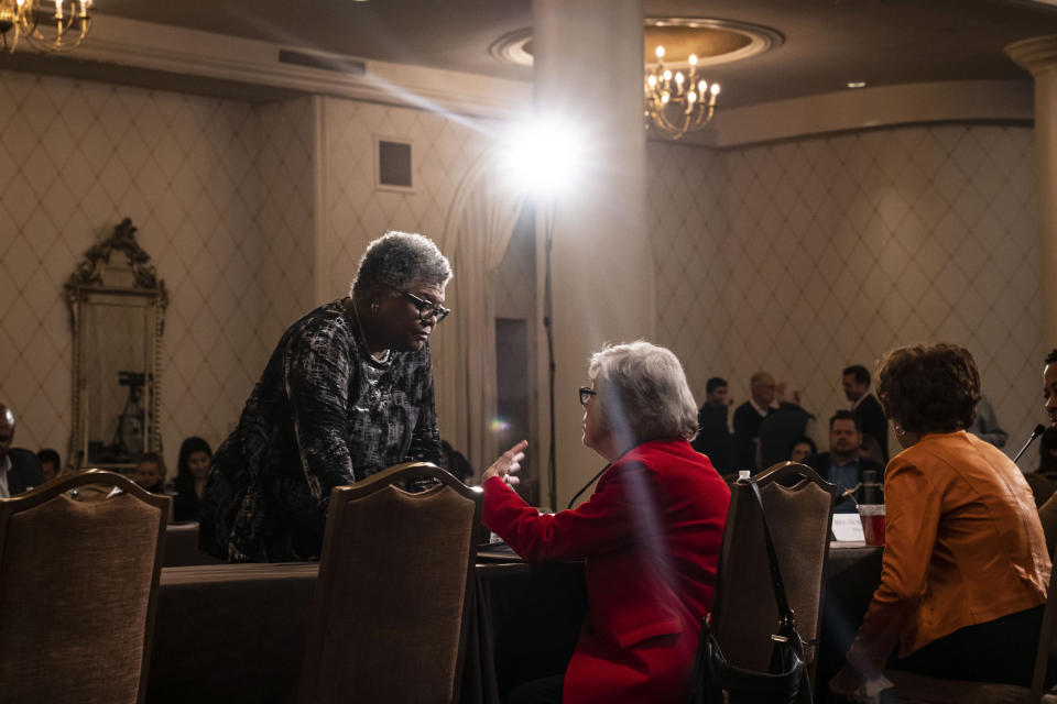 Committee members Joanne Dowdell of New Hampshire, left, and Carol Fowler of South Carolina talk prior to a vote on proposed changes to the primary system during a Democratic National Committee Rules and Bylaws Committee meeting to discuss President Biden's presidential primary lineup at the Omni Shoreham Hotel on Friday, Dec. 2, 2022, in Washington. (AP Photo/Nathan Howard)