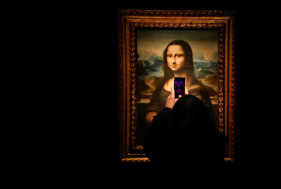 A visitor takes a photo of a copy of the Leonardo da Vinci's Mona Lisa, which will go up for auction on November 9, at the Artcurial auction house in Paris, France, November 5, 2021. REUTERS/Noemie Olive