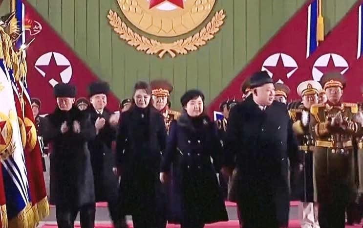 North Korean leader Kim Jong Un, center-right, walks to his seat to observe a military parade in Pyongyang, North Korea, with his young daughter Kim Ju Ae walking next to him, February 8, 2023. / Credit: North Korean state TV