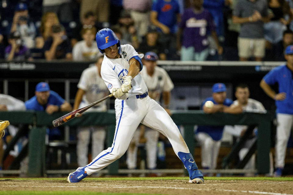 Florida's Luke Heyman hits a sacrifice fly for a walkoff win against Virginia in the ninth inning of a baseball game at the NCAA College World Series in Omaha, Neb., Friday, June 16, 2023. (AP Photo/John Peterson)