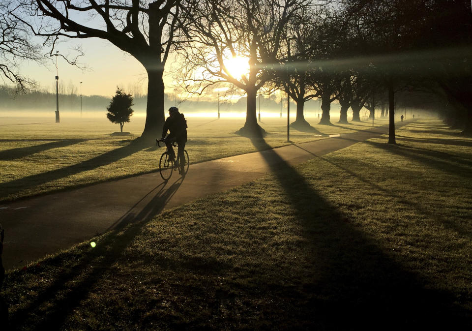 FILE - In this June, 26, 2017, file photo, a cyclist makes his way through a mist covered Hagley Park in central Christchurch, New Zealand. Despite its tranquility and beauty, New Zealand city of Christchurch is painfully familiar with trauma and will need to use that experience to recover from terrorist attack. (AP Photo/Mark Baker, File)