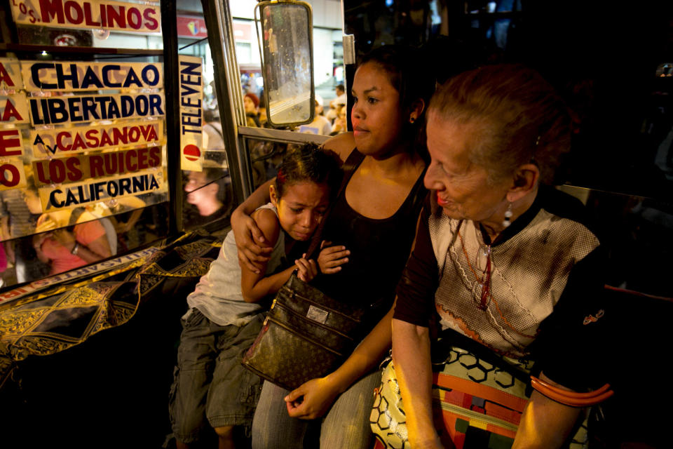 A frightened little boy hugs his mother as they travel in a public bus stuck in traffic caused by a protest against the arrest of four students in Caracas, Venezuela, Saturday, Feb. 8, 2014. The detained students were arrested in Tachira state on Friday while protesting crime. The protests are part of a civil movement called "Street with no return" that is calling for street protests against the government of Venezuela's President Nicolas Maduro. (AP Photo/Alejandro Cegarra)