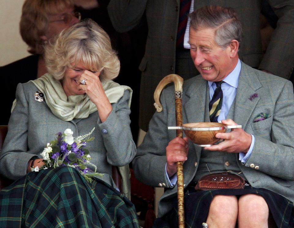 Charles, the then-Prince of Wales, and his wife Camilla, the then-Duchess of Cornwall, in their role as the Duke and Duchess of Rothesay, drink whisky from a Quaich given to them as a wedding gift at the 2005 Mey Games at Queens Park (Getty Images)