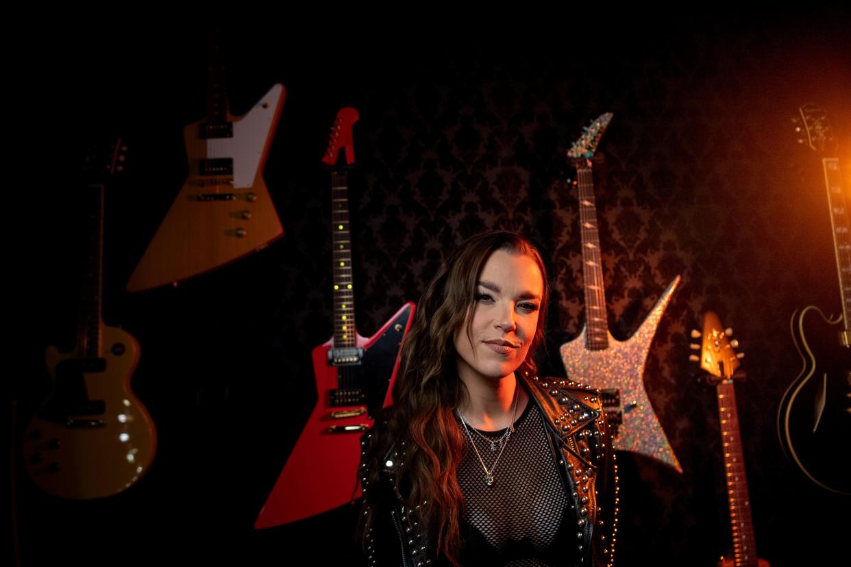 Lzzy Hale, lead singer of the rock band Halestorm, stands in front of some of her custom guitars at Gibson Garage in Nashville.