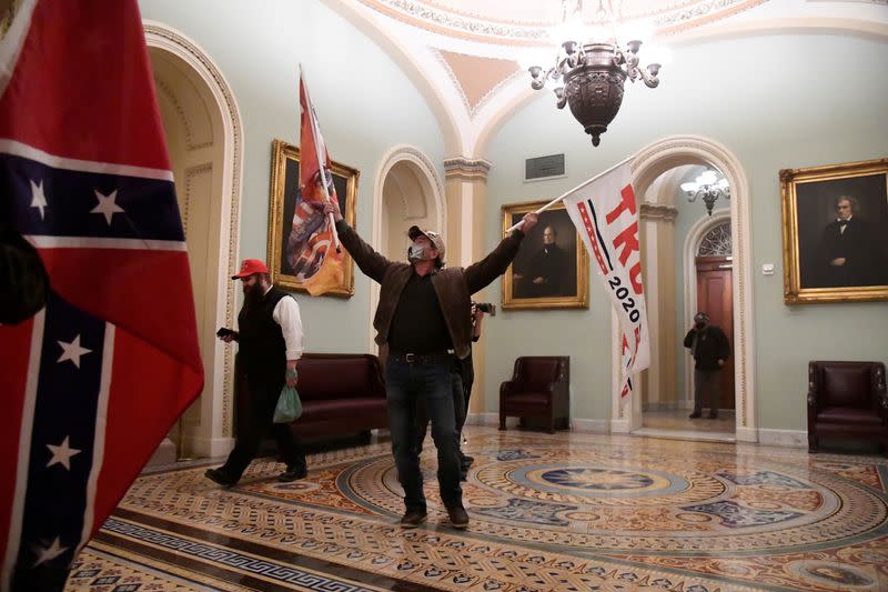 FOTO DE ARCHIVO. Los partidarios del presidente de Estados Unidos, Donald Trump, ondean banderas de Trump y banderas de batalla confederadas mientras se manifiestan en el segundo piso del Capitolio, cerca de la entrada del Senado después de violar las defensas de seguridad, en Washington DC, Estados Unidos