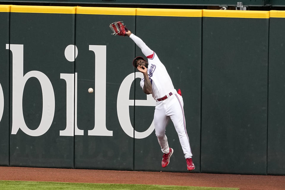 Texas Rangers right fielder Adolis Garcia misplays a ball hit off the bat of Kansas City Royals' Salvador Perez in the first inning of a baseball game, April 10, 2023, in Arlington, Texas. Bobby Witt Jr. scored on the error by Diaz. (AP Photo/Tony Gutierrez)