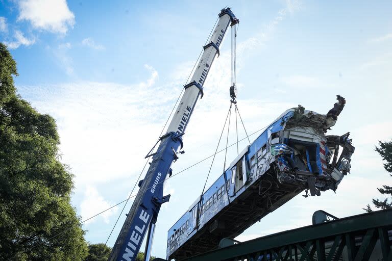 Una grúa de gran porte retira el vagón chocado, en las vías del tren San Martín