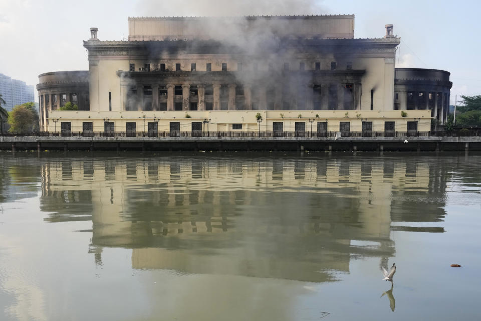 Smoke billows from the still smoldering Manila Central Post Office as a fire hits early Monday, May 22, 2023 in Manila, Philippines. A massive fire tore through Manila's historic post office building overnight, police and postal officials said Monday. (AP Photo/Aaron Favila)