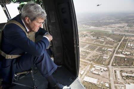 U.S. Secretary of State John Kerry looks out over Baghdad from a helicopter in this September 10, 2014 file photo. REUTERS/Brendan Smialowski/Pool/Files