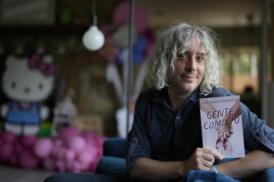 El escritor José Ignacio Valenzuela posa con su más reciente libro "Gente como yo" el jueves 6 de abril de 2023, en la casa donde vive con su pareja y su hija en Palmetto Bay, Florida. (Foto AP/Rebecca Blackwell)