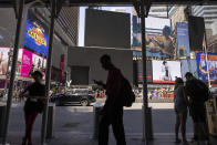 Pedestrians walk by blacked out screens due to a global technology outage in Times Square, Friday, July 19, 2024, in New York. (AP Photo/Yuki Iwamura)