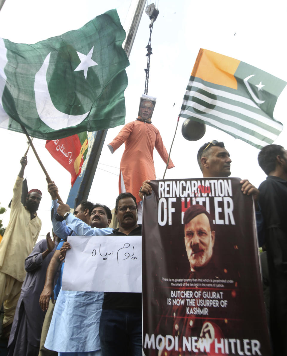 Pakistani protesters hang an effigy of Indian Premier Narendra Modi during a rally against India on their Independence Day, in Karachi, Pakistan, Thursday, Aug. 15, 2019. Pakistanis have rallied urging the world community to take notice of human rights abuses in the disputed Muslim-majority Himalayan region of Indian Kashmir. Sign left reads, "Black day." (AP Photo/Fareed Khan)