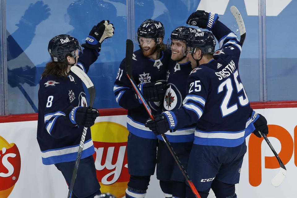 Winnipeg Jets' Sami Niku (8), Kyle Connor (81), Nikolaj Ehlers (27) and Paul Stastny (25) celebrate Connors' goal against Montreal Canadiens goaltender Carey Price during second-period NHL hockey game action in Winnipeg, Manitoba, Thursday, Feb. 25, 2021. (John Woods/The Canadian Press via AP)