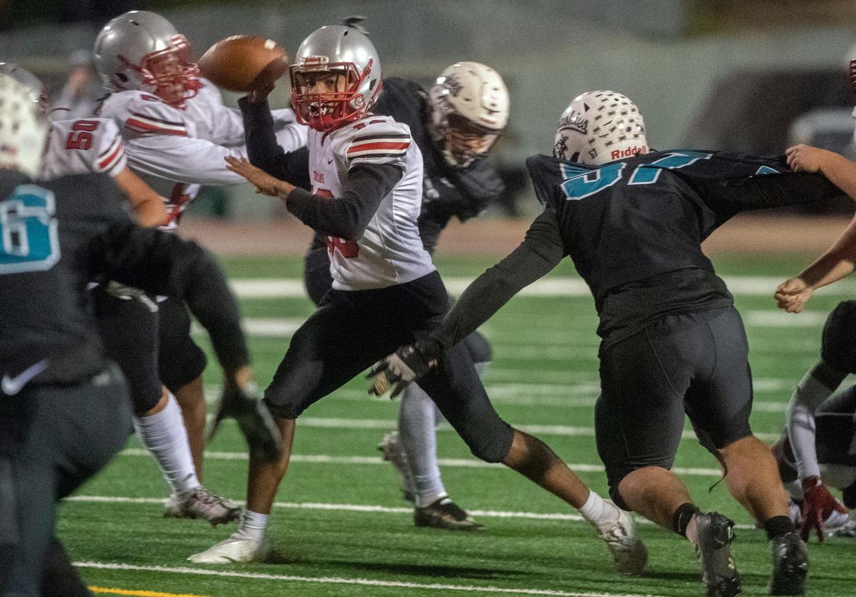 Lincoln's Martin Tokmo, left, throws a pass under pressure from Sheldon's Isiah Whiteside during a Sac-Joaquin Section first round varsity football playoff game at Sheldon High School in Sacramento on Friday, Nov. 4, 2022. 