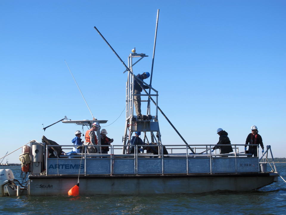 Workers hoist poles into position so they can take sediment samples from the floor of the harbor in Charleston, S.C., on Friday, Nov. 9, 2012. The samples are required for a study of a $300 million deepening of the harbor shipping channel so it can handle larger container ships. (AP Photo/Bruce Smith)