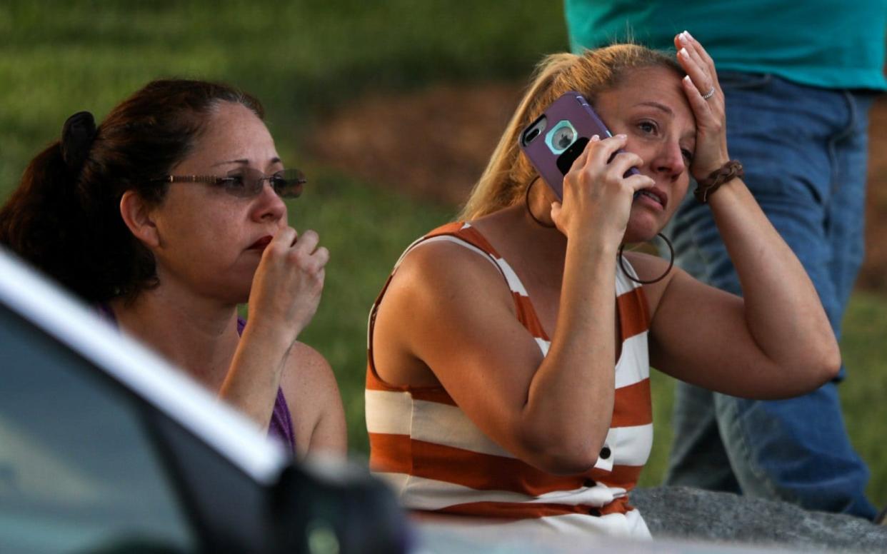 Family members and friends wait for their loved ones at a staging area after a shooting on the campus of University of North Carolina - AFP