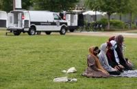 Pro-Palestinian protesters pray near open police vans on the campus of Washington University, Saturday, April 27, 2024, in St. Louis, Mo. Dozens were arrested during the protest. (Christine Tannous/St. Louis Post-Dispatch via AP)