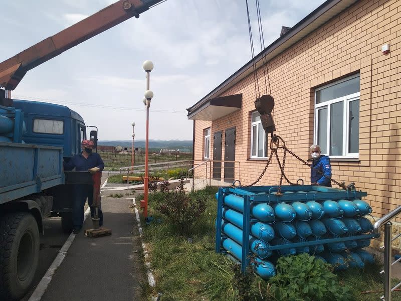 Workers unload oxygen balloons outside a local hospital in Dagestan’s Gurbuki village