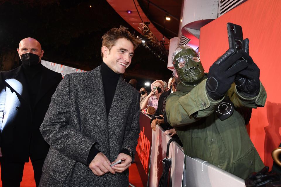 Robert Pattinson stops for a selfie with a fan dressed as the Riddler at a screening of "The Batman" in London.