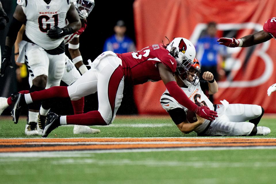 Arizona Cardinals linebacker Jesse Luketa (43) hits Cincinnati Bengals quarterback Jake Browning (6) as he slides. Luketa is called for a late hit in the first half of the NFL preseason game between the Cincinnati Bengals and the Arizona Cardinals at Paycor Stadium. Albert Cesare / The Enquirer