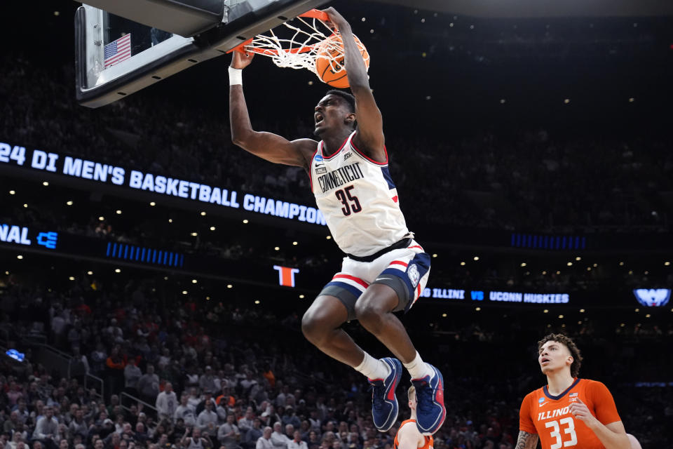 UConn forward Samson Johnson (35) slams a dunk against Illinois forward Coleman Hawkins (33) during the first half of the Elite 8 college basketball game in the men's NCAA Tournament, Saturday, March 30, 2024, in Boston. (AP Photo/Steven Senne)
