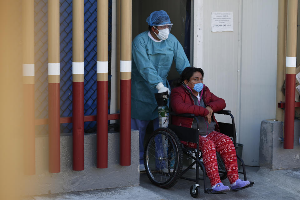 A medical worker moves a patient from the COVID-19 triage unit at Mexico General Hospital, in Mexico City, Monday, May 25, 2020. Authorities have predicted that coronavirus cases in the city would peak in May, with reopening measures currently slated for mid-June. (AP Photo/Rebecca Blackwell)