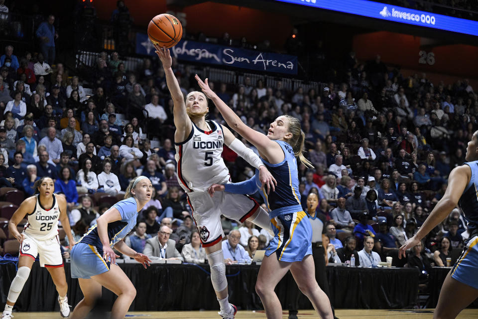 FILE - UConn guard Paige Bueckers makes a basket as Marquette guard Lee Volker, right, defends during the first half of an NCAA college basketball game in the semifinals of the Big East Conference tournament, Sunday, March 10, 2024, in Uncasville, Conn. Bueckers was selected to The Associated Press All-America women’s NCAA college basketball first team, Wednesday, March 20, 2024. (AP Photo/Jessica Hill, File)