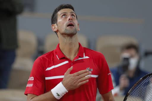 Serbia's Novak Djokovic celebrates winning his semifinal match of the French Open tennis tournament against Greece's Stefanos Tsitsipas in five sets, 6-3, 6-2, 5-7, 4-6, 6-1, at the Roland Garros stadium in Paris, France, Friday, Oct. 9, 2020. (AP Photo/Michel Euler)