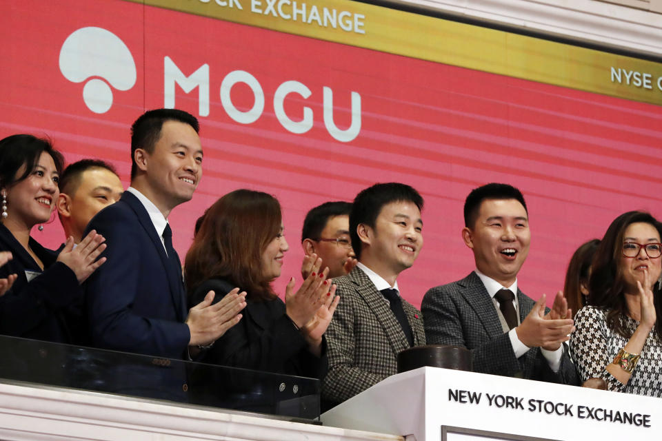 Mogu Inc. co-founder, Chairman and CEO Shark Chen, center, rings the New York Stock Exchange opening bell marking his company's IPO, Thursday, Dec. 6, 2018. (AP Photo/Richard Drew)