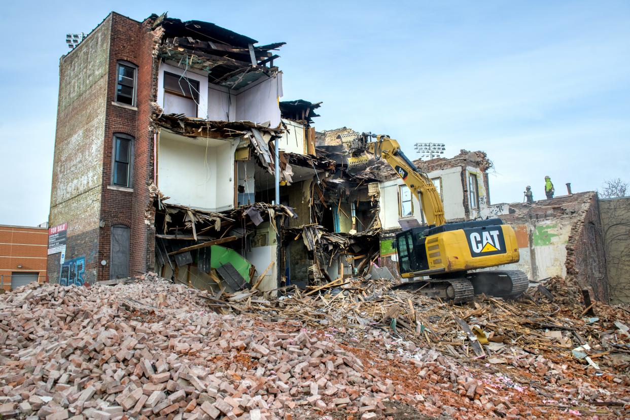 A Caterpillar excavator pulls down sections of the former Julian Hotel at 724 SW Adams Street on Tuesday, Dec. 19, 2023 in Peoria. The building had been vacant since 2002.