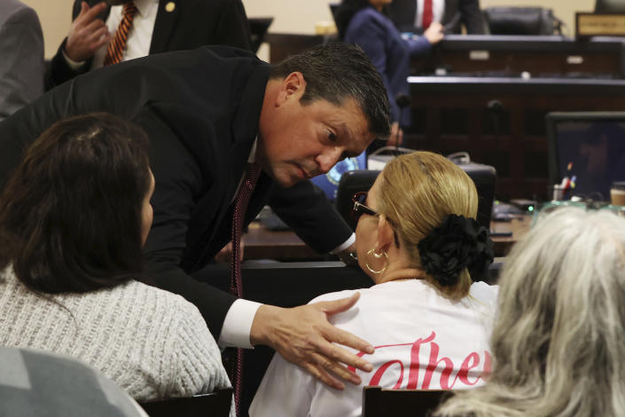 Webb County District Attorney Isidro R. "Chilo" Alaniz comforts victims' family members before the first day in the capital murder trial of former U.S. Border Patrol agent Juan David Ortiz, before Webb County State District Court Judge Oscar J. Hale, Monday, Nov. 28, 2022. Ortiz is charged in the 2018 deaths of four women near Laredo. The trial was moved to San Antonio because of pretrial media coverage in Laredo. (Jerry Lara/The San Antonio Express-News via AP)