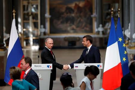 French President Emmanuel Macron (R) and Russian President Vladimir Putin (L) shake hands at a joint press conference at the Chateau de Versailles before the opening of an exhibition marking 300 years of diplomatic ties between the two countries in Versailles, France, May 29, 2017. REUTERS/Philippe Wojazer