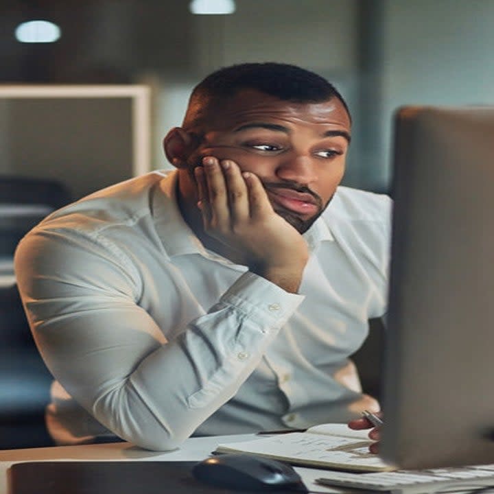 A man looking tired in front of his computer