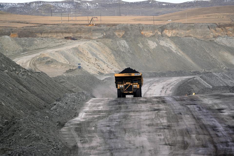 A loaded hauler ferries freshly dug coal from the Eagle Butte mine outside Gillette, Wyoming. Wyoming's coal mines are open pit, which means workers blast and dig away the top layers of dirt to reach the coal seams below, and then cover the area back up once the coal is gone. 