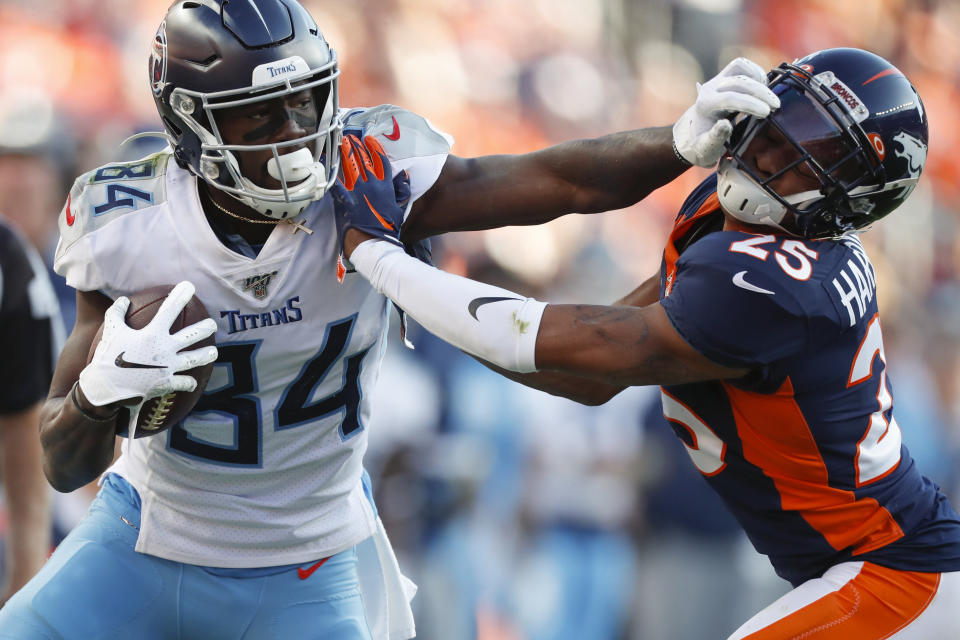 Tennessee Titans wide receiver Corey Davis, left, pushes off Denver Broncos cornerback Chris Harris during the second half of an NFL football game Sunday, Oct. 13, 2019, in Denver. (AP Photo/David Zalubowski)