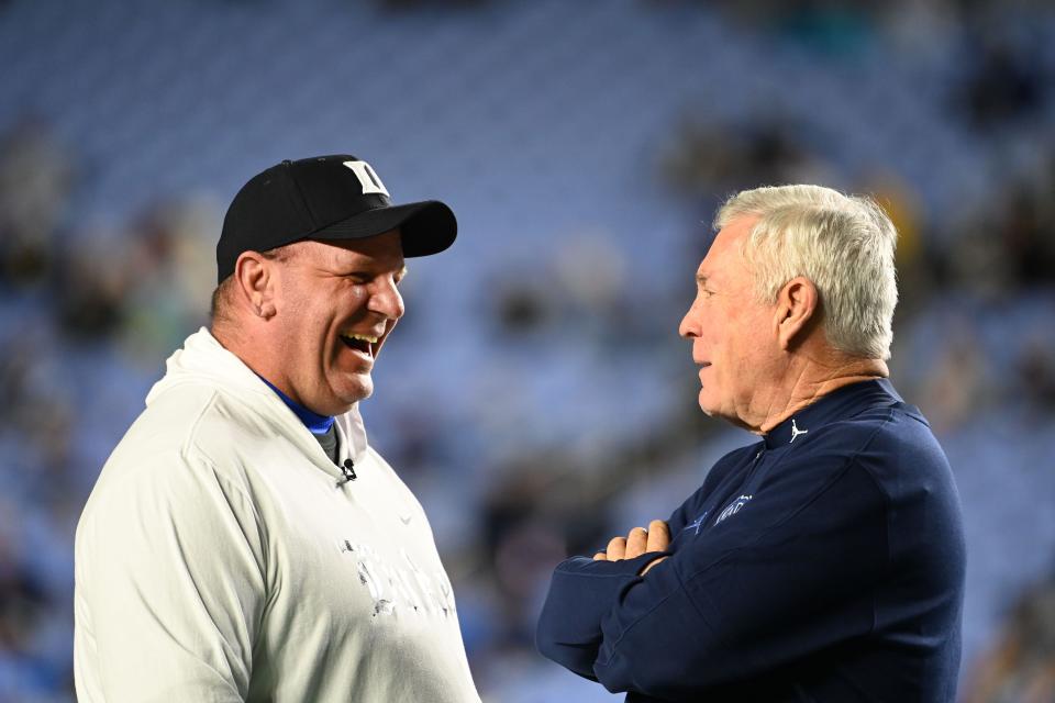 Mike Elko, left, meets with North Carolina coach Mack Brown before Duke's game against the Tar Heels on Nov. 11 . Elko is the new head coach at Texas A&M. The Aggies and Texas Longhorns will renew their rivalry Nov. 30.