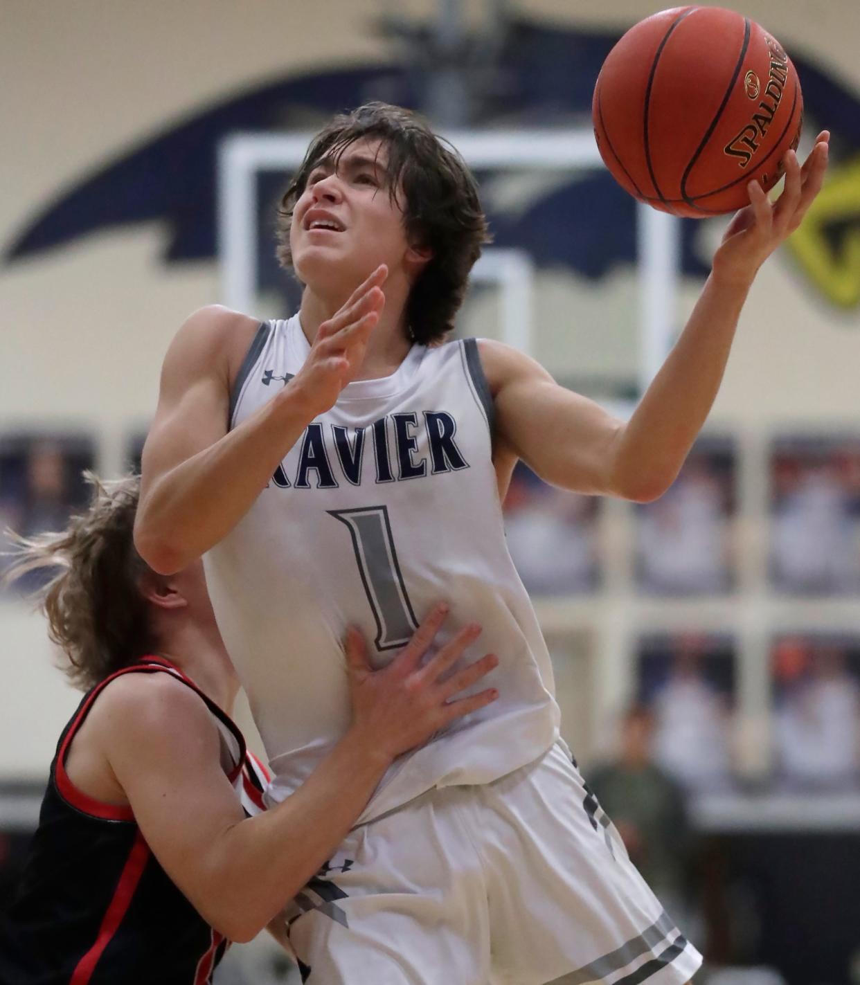 Xavier's Sam Pfefferle (1) drives to the basket against Seymour during their boys basketball game Jan. 23 in Appleton.