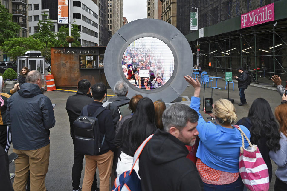 People in New York interact with a livestream video portal with Dublin. (STAR MAX / AP)