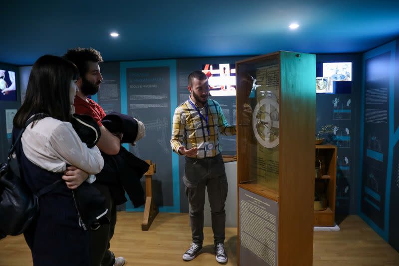 A Kotsanas Museum of Ancient Greek Technology employee presents a replica of the ancient Antikythera Mechanism, in Athens