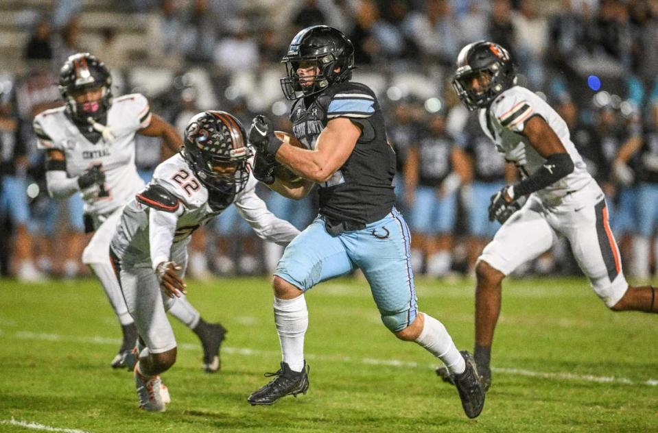 Clovis North’s Jackson Cinfel, center, eludes the Central defense on his way to a Bronco touchdown in the first half of their Tri-River Athletic Conference football final at Veterans Memorial Stadium on Thursday, Oct. 26, 2023.