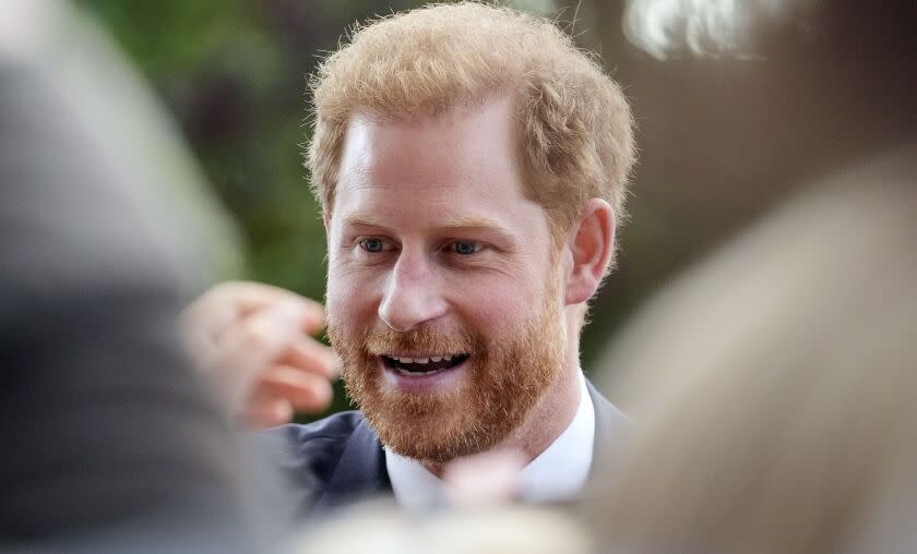 A man with red hair and a beard speaking to people