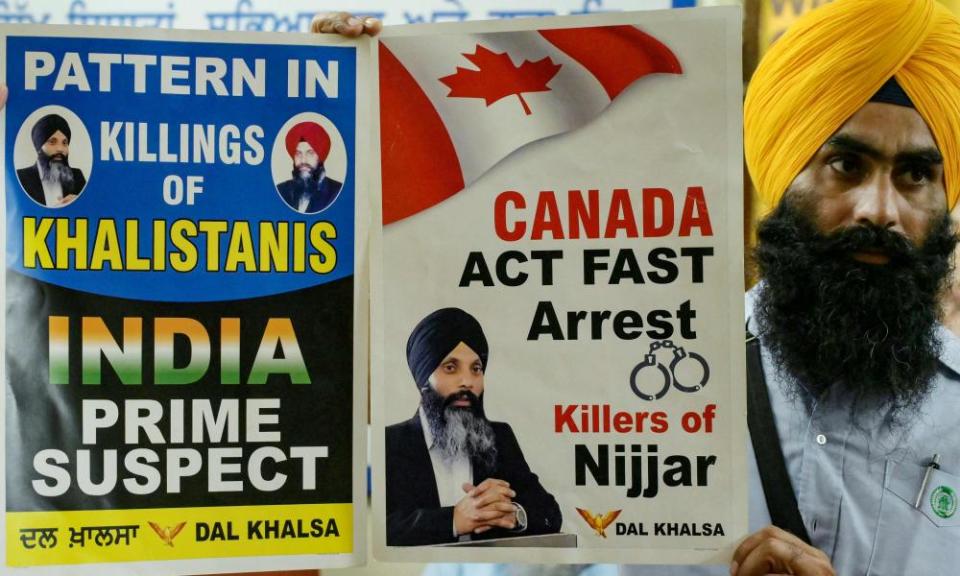 A member of a Sikh organisation holds a placard displaying posters of Hardeep Singh Nijjar in Amritsar, India