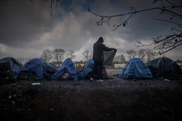 CALAIS, FRANCE - NOVEMBER 27: A refugee folds his blanket at a migrant camp on the outskirts of Calais on November 27, 2021 in Calais, France. There currently around 1800 migrants and refugees currently living outside in Northern France. At least 27 people including five women and a young girl died on Wednesday trying to cross the Channel to the UK in an inflatable dinghy in an incident in which the International Organisation for Migration described as the biggest single loss of life in the Channel since it began collecting data in 2014. (Photo by Kiran Ridley/Getty Images) (Photo: Kiran Ridley via Getty Images)