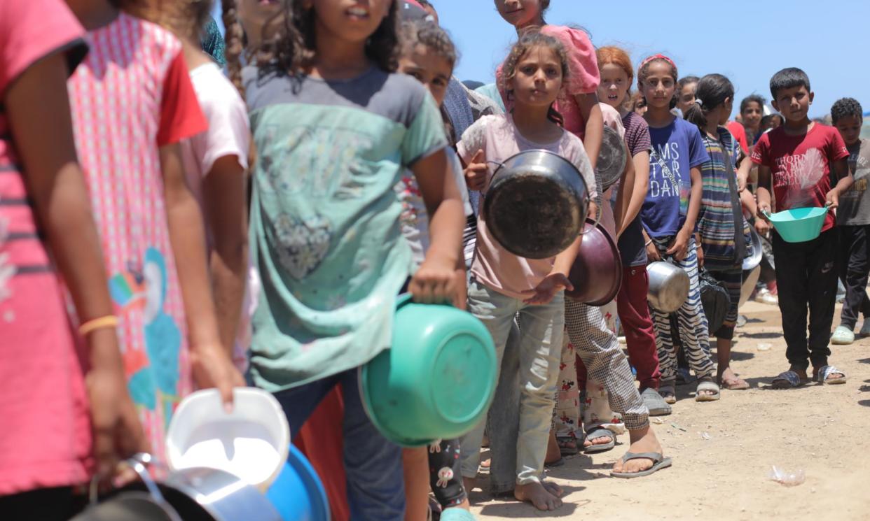 <span>Palestinians wait for food aid in Deir al-Balah, Gaza, in May.</span><span>Photograph: Anadolu/Getty Images</span>