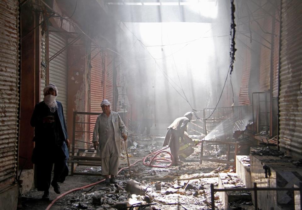 Firefighters spray water on burning shops in Ghazni city, Afghanistan, after a Taliban attack on August 14, 2018. The Taliban recently seized a checkpoint in Ghazni, as the group's control in the country continues to grow.