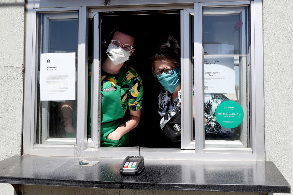 EDGEWATER, COLORADO - APRIL 07:  Starbucks employees wear a mask while working the drive-thru window on April 07, 2020 in Edgewater, Colorado. Starting today Starbucks will require all employees to wear facemasks at work. The chain has closed in-store cafes however drive-thru locations remain open. (Photo by Matthew Stockman/Getty Images)
