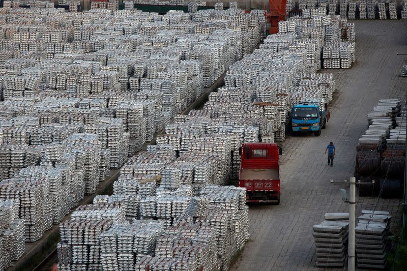 FILE PHOTO: A worker walks through an aluminium ingots depot in Wuxi